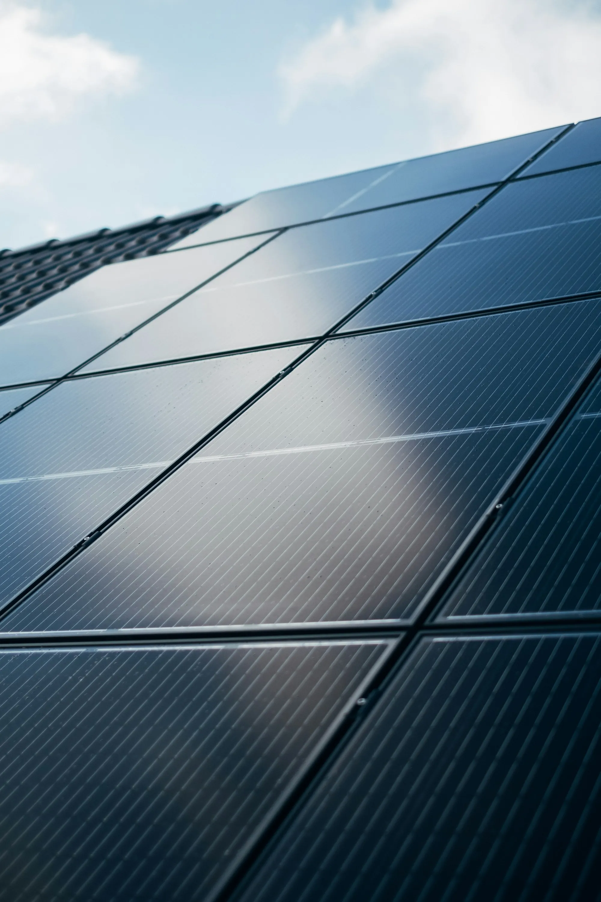 Close-up of black solar panel cells with light reflecting off the glass
